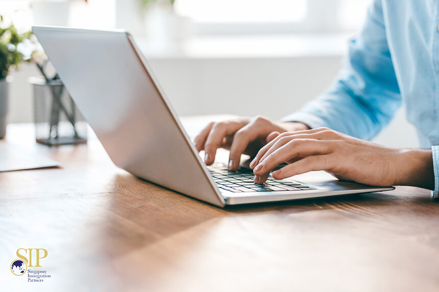 A Person Typing On A Laptop