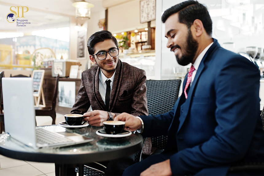 two business professionals in suits having coffee while in a discussion